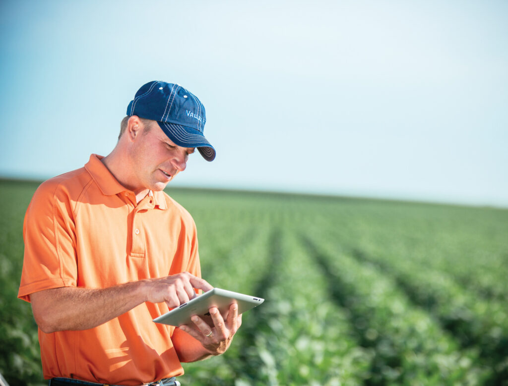 Man looking at iPad using Autonomous Crop Management Technology
